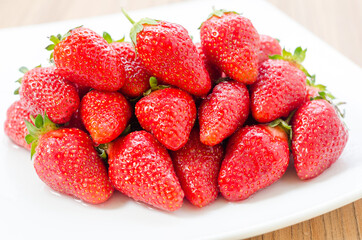 Fresh and natural garden strawberries on a white plate