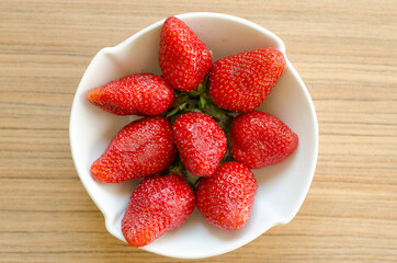 Fresh and natural garden strawberries in a white ceramic bowl