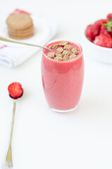 Glass of fresh and healthy strawberry  smoothie  (milkshake) drink with brown cookie. On white background..
