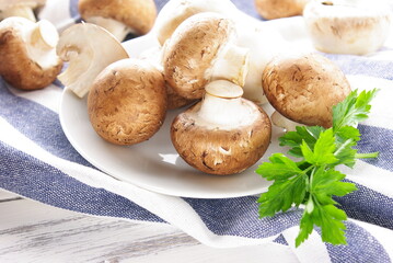 Mushrooms, parsley on a white plate, on a light napkin