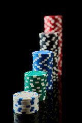 Stack of Casino gambling chips isolated on black reflective background