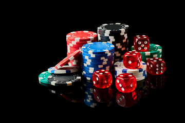 Casino chips and dices on dark reflective background with copy space