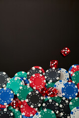 Frame made of Casino chips and dices on dark reflective background with copy space