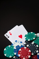 Obraz premium Casino chips and playing cards on dark reflective background