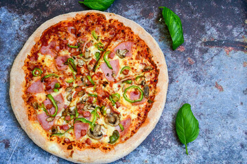  Close up of    hot italian pizza   classic ham. Fresh basil,tomato sauce ,mozzarella cheese , mushrooms and  minced meat .Concept poster for Restaurants or pizzerias. Top view