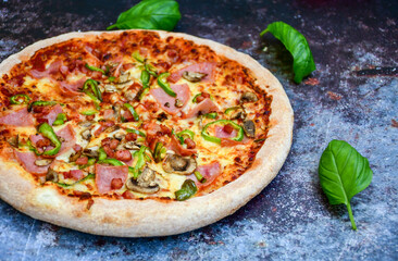  Close up of    hot italian pizza   classic ham. Fresh basil,tomato sauce ,mozzarella cheese , mushrooms and  minced meat .Concept poster for Restaurants or pizzerias. Top view