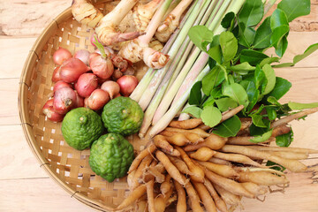 Fresh many vegetables is the herb in a wicker basket isolated on wooden background closeup.