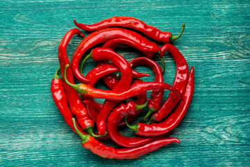 Red hot chili peppers on green background - Flat lay