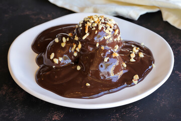 Chocolate profiteroles dessert on a dark wooden background
