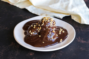 Chocolate profiteroles dessert on a dark wooden background