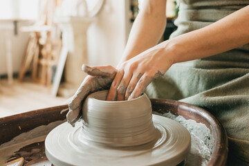 A female craftsman works in a clay workshop on a potter's wheel. The concept of creative people. Closeup