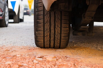 Zoom at car wheel tire on gravel stone street