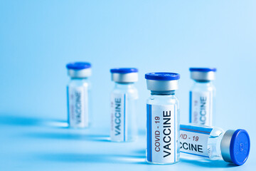 vial of Covid 19 vaccine on cyan background.