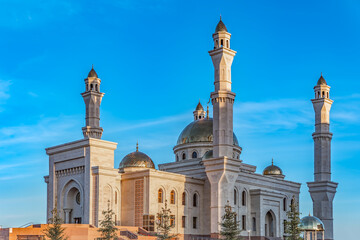 A Muslim Islamic mosque with golden minarets and a crescent moon against the sky.A religious temple for praying and worshipping the God of Muslims in Islamic culture and belief in Allah.