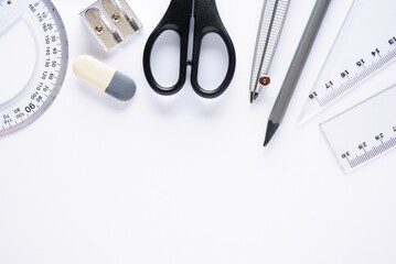 Pencil, scissors, compasses, ruler on a white background, flatlay