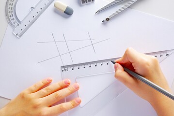 Pencils, compasses, ruler, eraser, a child draws a drawing