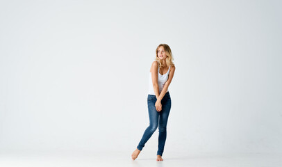 Fototapeta na wymiar woman in jeans barefoot stands on the floor fashion emotions motion
