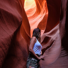 Young woman tourist standing inside Antelope Canyon in Arizona during a visit inside the rift