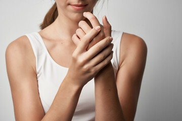 woman in white t-shirt holds hand health problems chronic pain