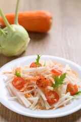 Salad with sliced kohlrabi, carrot, tomato and mizuna leaf on white dish, Vegan food, Healthy eating