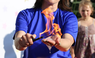 A girl sets fire to soap bubbles on her hand during the show of soap bubbles. Flame in the palm of your hand