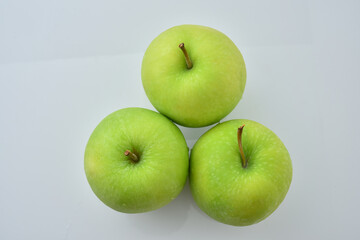Three green apples on a white background