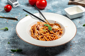 Traditional Italian spahgetti Bolognaise with tomato and meat mince sauce served in a plate with parmesan cheese