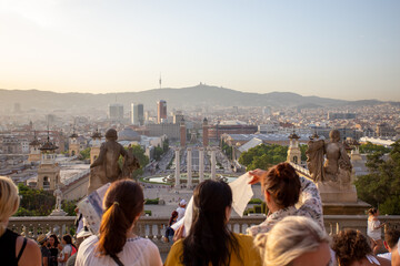 A group of girls tourist enjoying the sunset on the top of a mountain in Barcelona.