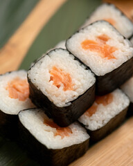 Classic maki sushi with rice and salmon in nori seaweed. Japanese meal. Close up shot. Soft focus.