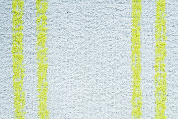 White, terry cloth towels. Two yellow stripes are symmetrically located on both sides. .The stripes are vertical. The image can be used as a texture or background. Copy space.