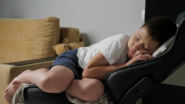 boy sleeping sweetly on a computer chair.