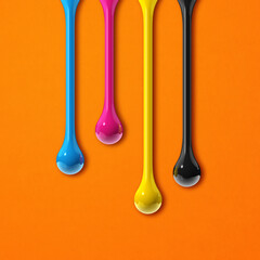 cmyk ink drops on orange paper square background