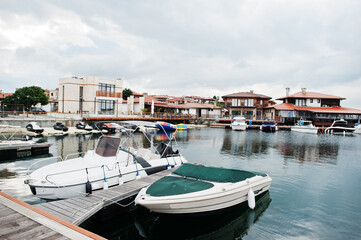 Fototapeta na wymiar Marine parking of modern motor boats with jet skies. Luxury yachts docked in sea port.