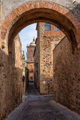 Fototapeta na wymiar Narrow alley with old stone buildings at Caceres, Extremadura, Spain.