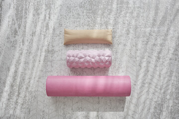 three different rollers for fitness and yoga lie on a white mat close-up