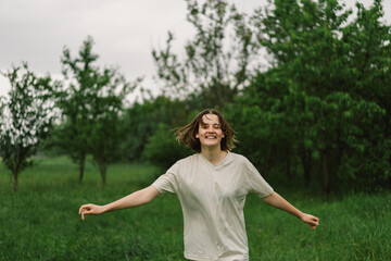 Close-Up Portrait Of Teenager Girl. Cheerful Teen Girl With Pronounced Face From Sprayed Small Splashes Of Water Or Warm Summer Rain In Outdoors.