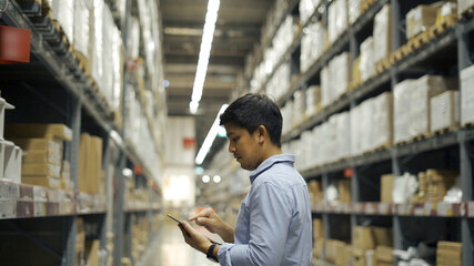 Man worker checking products with tablet in warehouse.