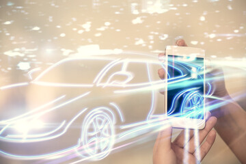 Double exposure of automobile icon hologram and woman holding and using a mobile device. Technology concept.