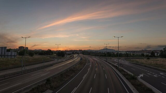 Beautiful day to night timelapse of busy highway with purple sky colors and traffic light trails during sunset