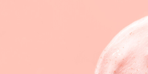 The texture of a scrub or shower gel on a pink background.