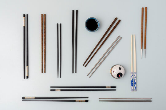 Top view image of Chinese, Japanese and Korean chopsticks, metal, wood and plastic. Soy sauce and anime cat