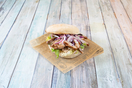 sandwich with chopped kebab roast meat, raw red onion and green endive on a rustic roll
