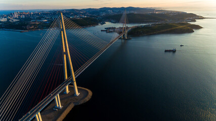 Russian bridge across the Eastern Bosphorus Strait in Vladivostok. View from above. Russian bridge against the background of a beautiful sunrise.
