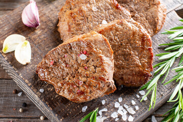 A piece of roast beef with spices served on a cutting board