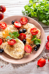 Fried chicken chop. Home fried chicken chop with tomatoes, olives and cheese on a wooden table. Rustic style.