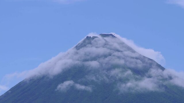 Arenal Volcano active andesitic stratovolcano With the movement of clouds and Black vulture Gliding around the summit