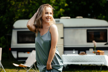 The girl stands near the trailer and enjoys the moment