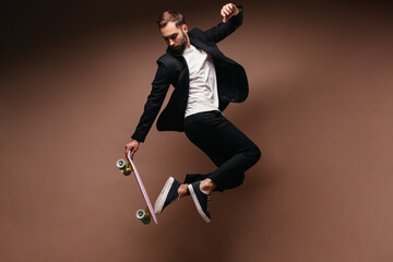 Stylish guy in suit jumping on skateboard © Look!