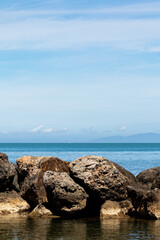 Fototapeta na wymiar Sea and rock background. Rock and blue sea with clear sky. Seaside travel destination background image. Clear blue sea and blue sky in summertime