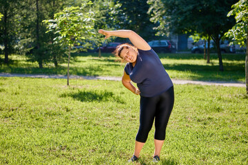 Lateral bending exercise by an obese, mature white woman.